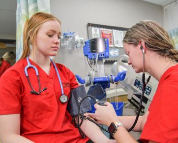 在博彩网址大全的BSN护理项目的学生测量彼此的血压.